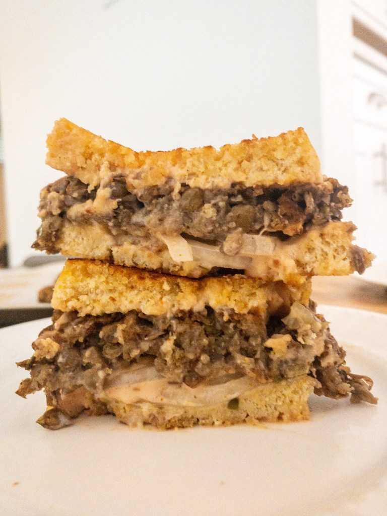 Vegan meaty lentil frisco melt made using lentils, frisco sauce, and onions pressed on a hot pan for a crispy golden outside with a tasty savory center.